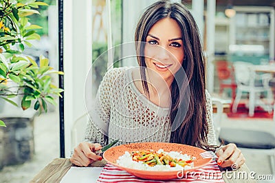 Young woman eating chinese food in a restaurant, having her lunch break Stock Photo