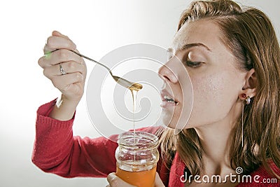 Young woman eating honey Stock Photo