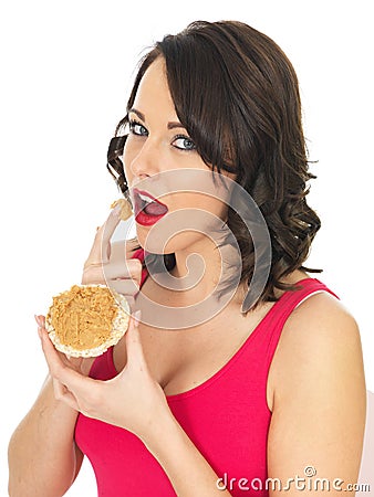 Young Woman Eating Peanut Butter on a Cracker Rice Cake Stock Photo
