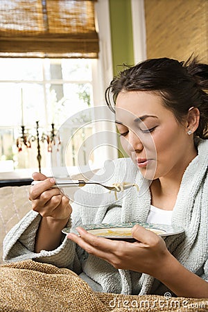 Young Woman Eating Soup Stock Photo