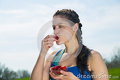 Young woman eating strawberries. Stock Photo