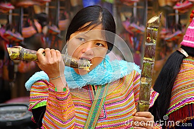 The young woman eats a sugar cane Editorial Stock Photo