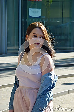 Young woman in an elegant pink dress in the city Stock Photo