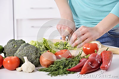 Woman cooking in new kitchen making healthy food with vegetables. Stock Photo