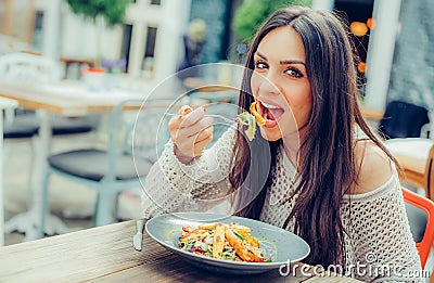 Young woman enjoying food in a restaurant, having her lunch break Stock Photo