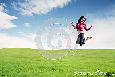 Young woman enjoying the new year jumping on field Stock Photo