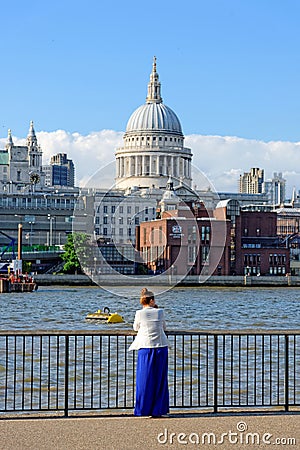 A young woman is enjoying the view of the majestic dome of St. Paul Cathedral Editorial Stock Photo