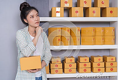 woman entrepreneur thinking with parcel box, online business, prepare before delivery Stock Photo