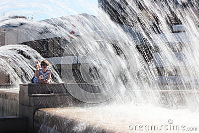 The young woman escaping heat wave in city fountain Stock Photo