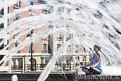 The young woman escaping heat wave in city fountain Stock Photo