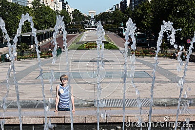 The young woman escaping heat wave in city fountain Stock Photo