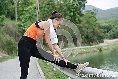 Young woman exercising at park. Beautiful athletic woman doing her stretches in the park. Sporty woman stretching after Stock Photo
