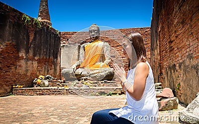 Young woman is exploring the ancient ruins of a buddhist temple Stock Photo