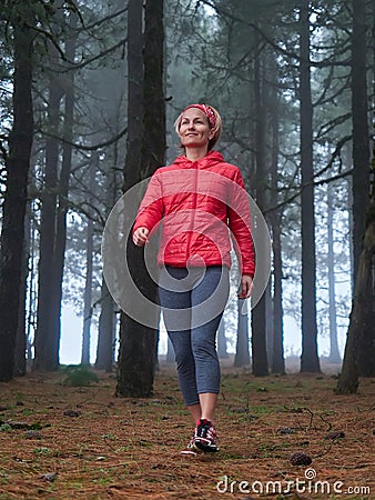 Young woman exploring stunning autumn foggy forest Stock Photo