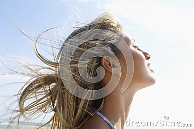 Young Woman With Eyes Closed Enjoying Sunlight Stock Photo