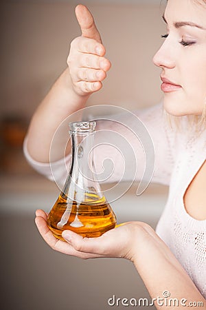 Young woman feeling oil flavor from jug Stock Photo