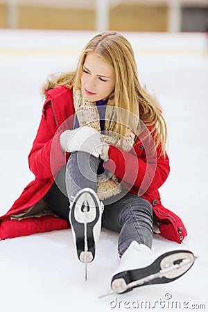 Young woman fell down on skating rink Stock Photo