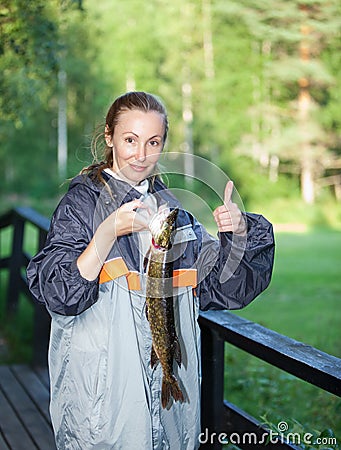 The young woman the fisherman with the caught pike Stock Photo