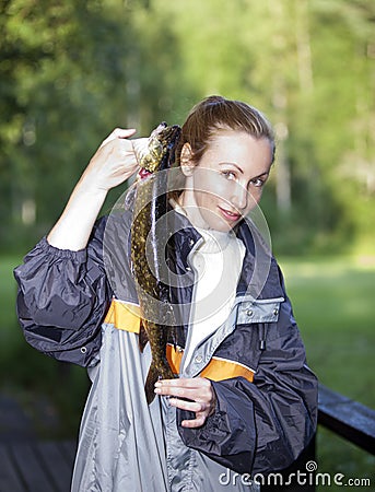 The young woman the fisherman with the caught pike Stock Photo