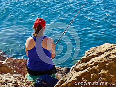 Young woman fishing by the ocean Editorial Stock Photo