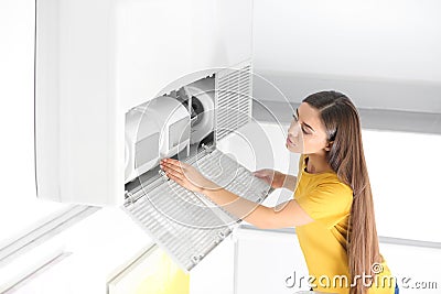 Young woman fixing air conditioner Stock Photo