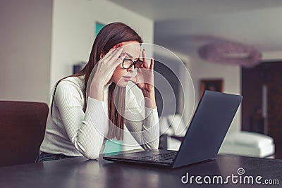 Young woman focusing on work at laptop in home office Stock Photo