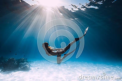 Young woman freediver glides over sandy sea Stock Photo