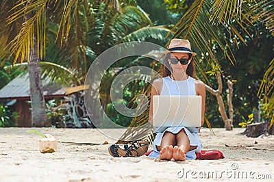 Young woman freelancer working in laptop on the beach. Freelance work Stock Photo