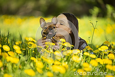 Young woman and a french bulldog puppy are resting in a park Stock Photo