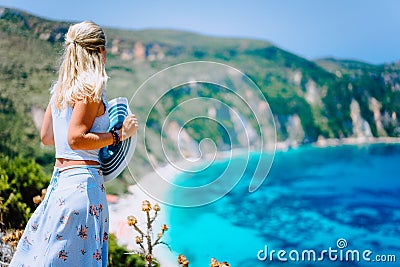 Young woman in front of Petani beach Kefalonia admiring highly excited picturesque panorama of emerald bay of Stock Photo
