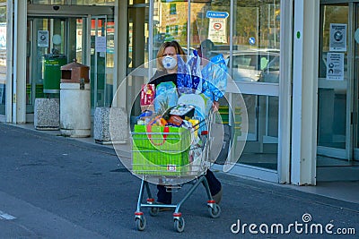 A young woman with a fully loaded shopping cart, groceries for Easter celebration, huge chocolate eggs in the cart Editorial Stock Photo