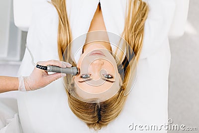 Blonde woman has ultrasonic dinamic lift massage in spa, hardware apparatus. Stock Photo