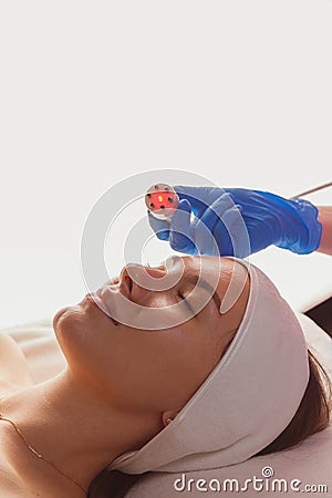 Young woman getting microcurrents skin cleansing and face treatment at beauty salon Stock Photo