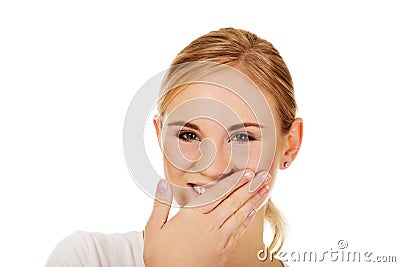 Young woman giggles covering her mouth with hand Stock Photo