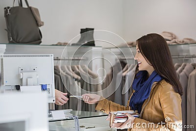 Young woman giving credit card to cashier Stock Photo