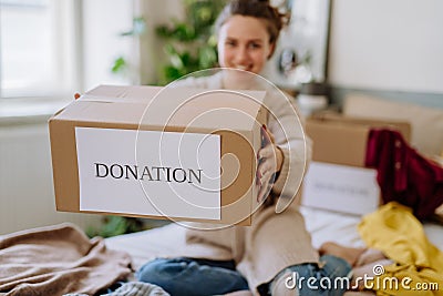 Young woman giving her clothes to charity. Stock Photo