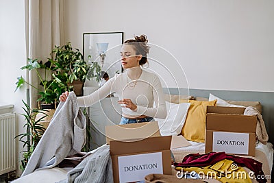Young woman giving her clothes to charity. Stock Photo