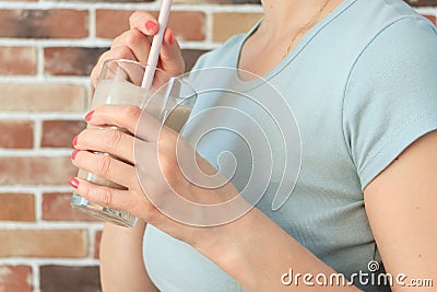 Young woman with a glass of healthy smoothie served with a straw, close-up view Stock Photo