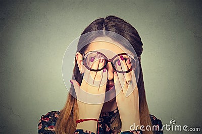 Young woman in glasses covering face eyes with hands Stock Photo