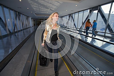 Young woman going on the travelator in a hurry Stock Photo