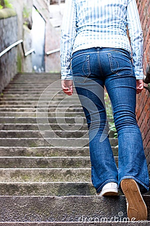 Young woman going up the stairs Stock Photo