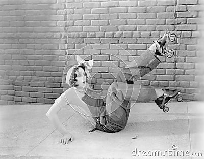 Young woman on the ground looking surprised after finding out that roller skating is a slippery subject Stock Photo