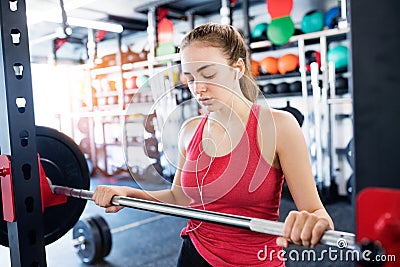 Young woman in gym, earphones in her ears,listening music Stock Photo