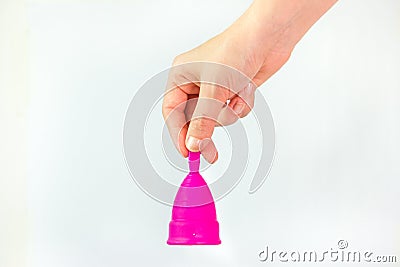 Young woman hand holding a pink menstrual cup like a bell Stock Photo