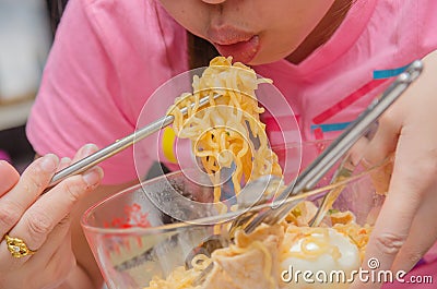 Young woman hand using chopstick blow hot and eating noodles Stock Photo