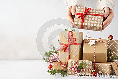 Young woman hands taking a gift box from a big stack of gifts Stock Photo