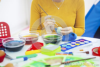 Young woman hands using a brush to color eggs Stock Photo