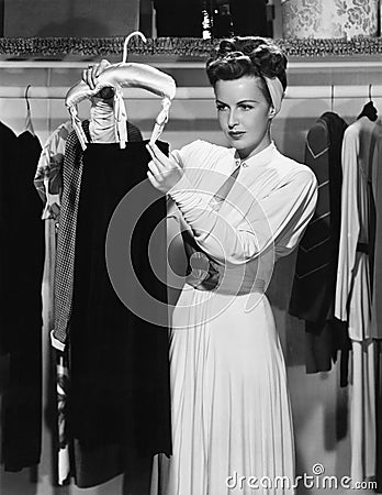 Young woman hanging up a skirt in the closet Stock Photo