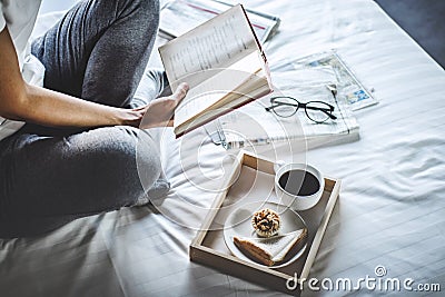 Young woman happiness on bedroom in enjoying reading books and n Stock Photo