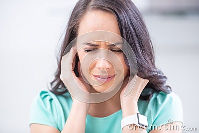 Young woman have headache migraine stress or tinnitus - noise whistling in her ears Stock Photo